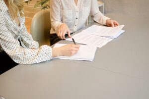 woman signing tax documents - Real Estate Accounting in Los Angeles - GJR Consulting